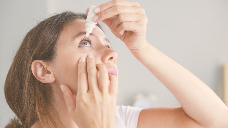 Woman applying lubricating eye drops for dry eye relief